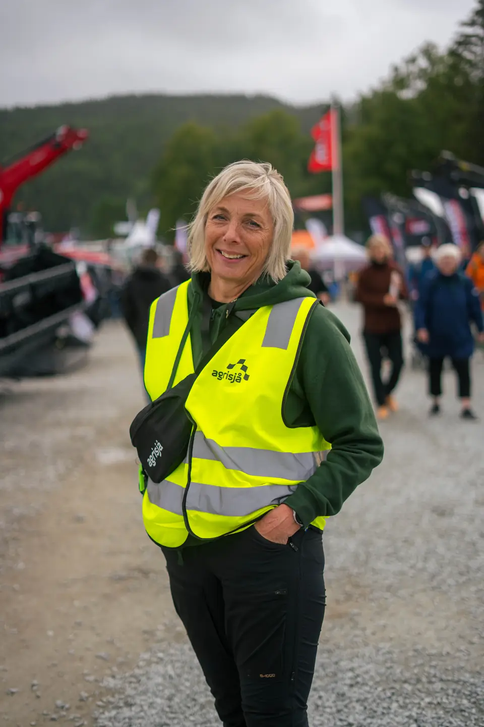 Messevert i gul refleksvest mellom stands